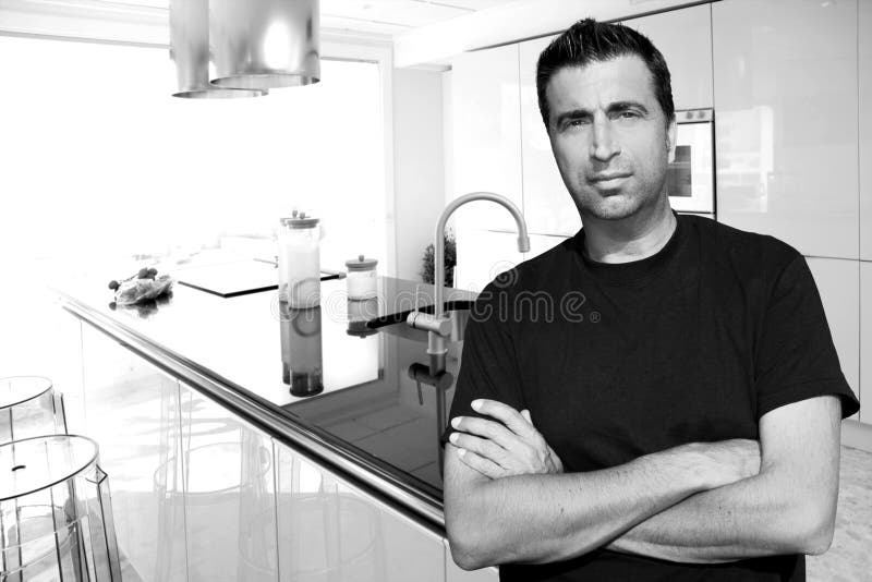 Medium age man in modern kitchen interior portrait crossed arms. Medium age man in modern kitchen interior portrait crossed arms