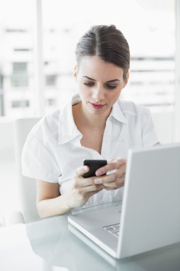 Μήνυμα επιχειρηματιών Brunette με το smartphone της στοκ φωτογραφία με δικαίωμα ελεύθερης χρήσης
