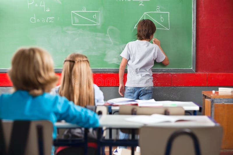 Μαθητής που γράφει σε Greenboard στην τάξη στοκ φωτογραφία Μαθητής που γράφει σε Greenboard στην τάξη στοκ φωτογραφία
