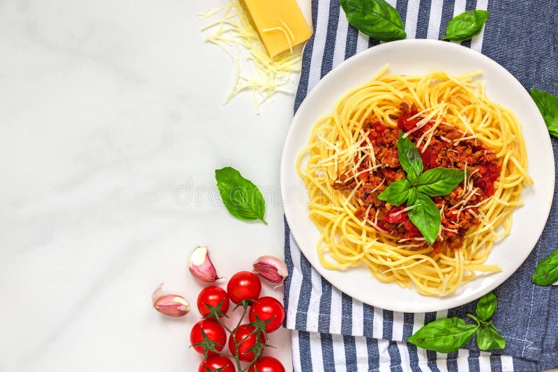 Μακαρόνια bolognese ζυμαρικών σε ένα άσπρο πιάτο στην πετσέτα κουζινών πέρα από τον άσπρο μαρμάρινο πίνακα τρόφιμα υγιή Τοπ όψη στοκ φωτογραφία