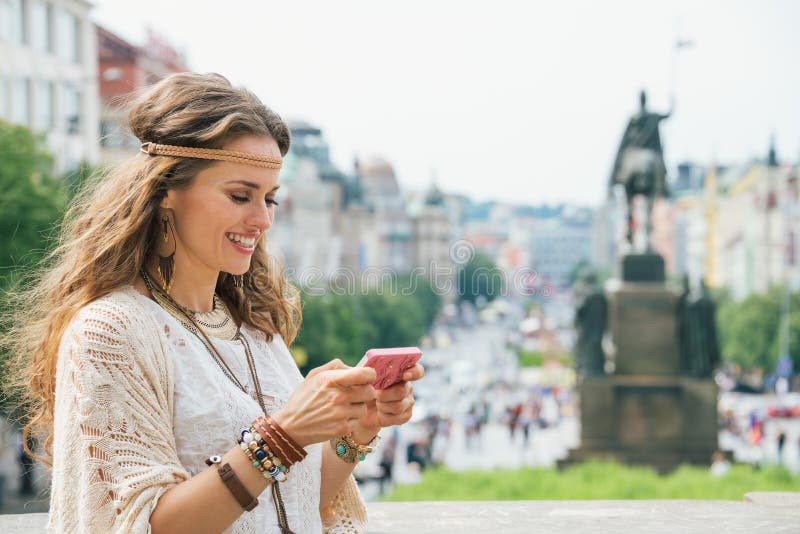 Μακρυμάλλης Βοημίας νέα κυρία που γράφει sms σε κινητό, Πράγα στοκ φωτογραφίες με δικαίωμα ελεύθερης χρήσης Μακρυμάλλης Βοημίας νέα κυρία που γράφει sms σε κινητό, Πράγα στοκ φωτογραφίες με δικαίωμα ελεύθερης χρήσης