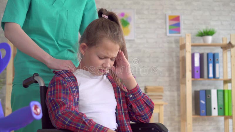 Μασέρ γιατρών που κάνει το μασάζ λαιμών σε ένα έφηβη σε μια αναπηρική καρέκλα κοντά επάνω