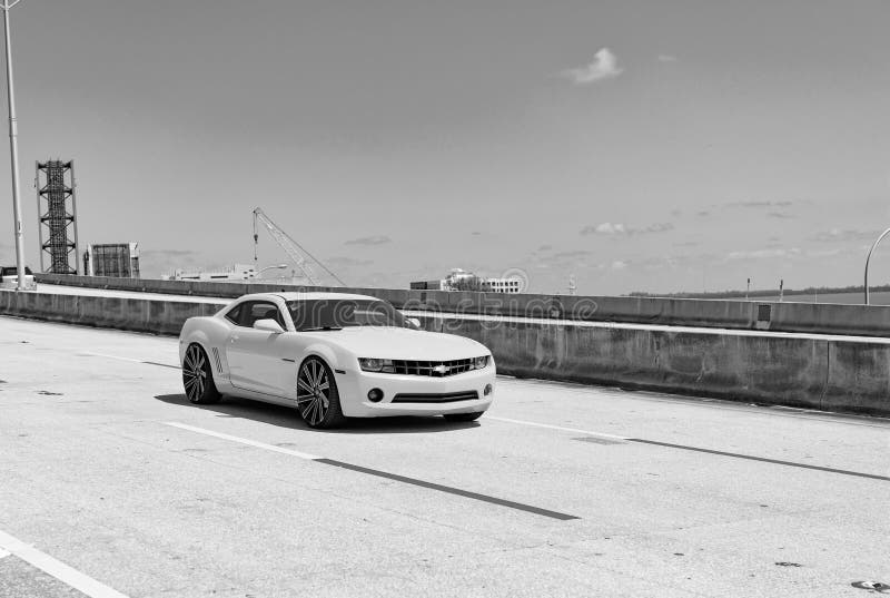 Miami, Florida USA - April 15, 2021: Chevrolet Camaro luxury yellow sport ar on road, corner view. Miami, Florida USA - April 15, 2021: Chevrolet Camaro luxury yellow sport ar on road, corner view.