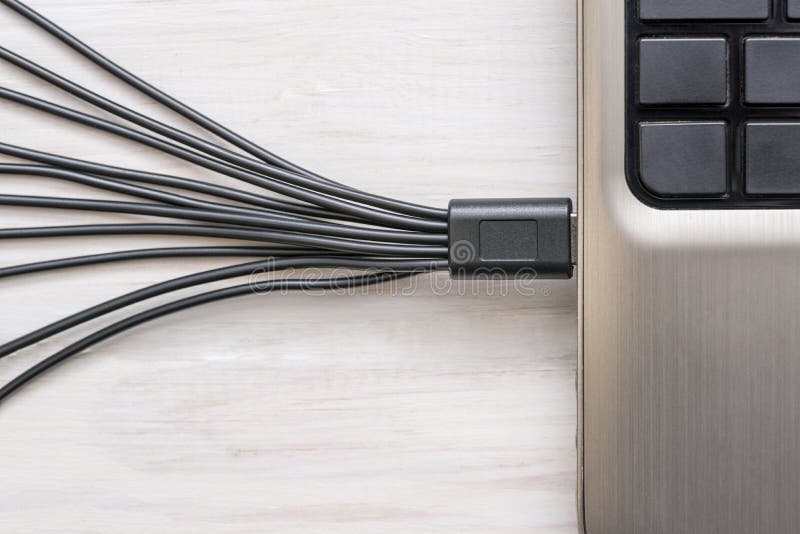 Μαύρα καλώδια USB που συνδέονται με το lap-top στο άσπρο ξύλινο υπόβαθρο στοκ φωτογραφίες με δικαίωμα ελεύθερης χρήσης Μαύρα καλώδια USB που συνδέονται με το lap-top στο άσπρο ξύλινο υπόβαθρο στοκ φωτογραφίες με δικαίωμα ελεύθερης χρήσης