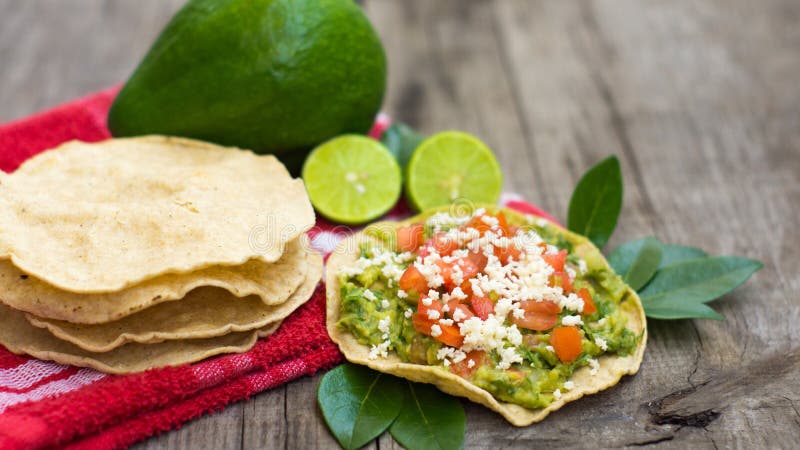 Mexican Tostadas with avocado and lemon on wooden background. Mexican Tostadas with avocado and lemon on wooden background.