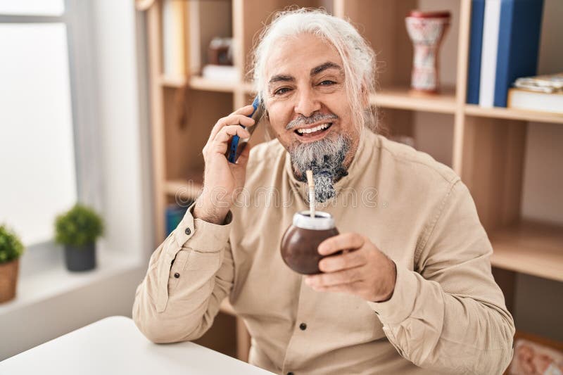 μεσήλικας άνδρας μιλάει με έγχυση smartphone στο σπίτι στοκ φωτογραφία