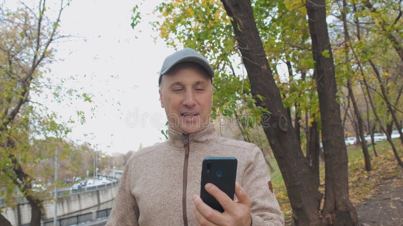 μεσαίος άνδρας που μιλάει σε ένα smartphone στο δρόμο χρησιμοποιώντας επικοινωνία βίντεο απόθεμα βίντεο