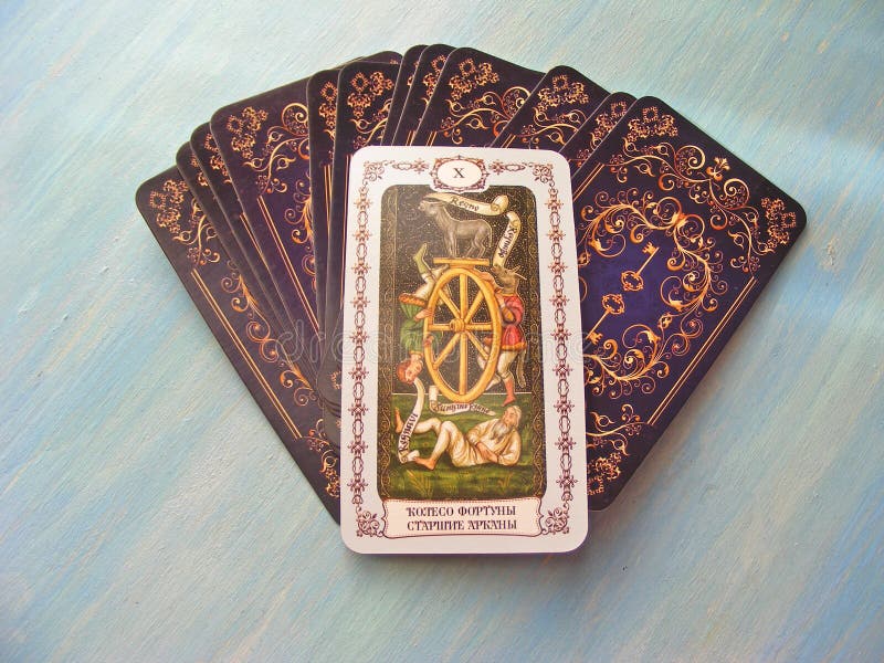 Μεσαιωνικός στενός επάνω καρτών Tarot με τη ρωσική ρόδα τίτλου των γεφυρών Tarot τύχης στο μπλε ξύλινο υπόβαθρο στοκ φωτογραφία με δικαίωμα ελεύθερης χρήσης Μεσαιωνικός στενός επάνω καρτών Tarot με τη ρωσική ρόδα τίτλου των γεφυρών Tarot τύχης στο μπλε ξύλινο υπόβαθρο στοκ φωτογραφία με δικαίωμα ελεύθερης χρήσης