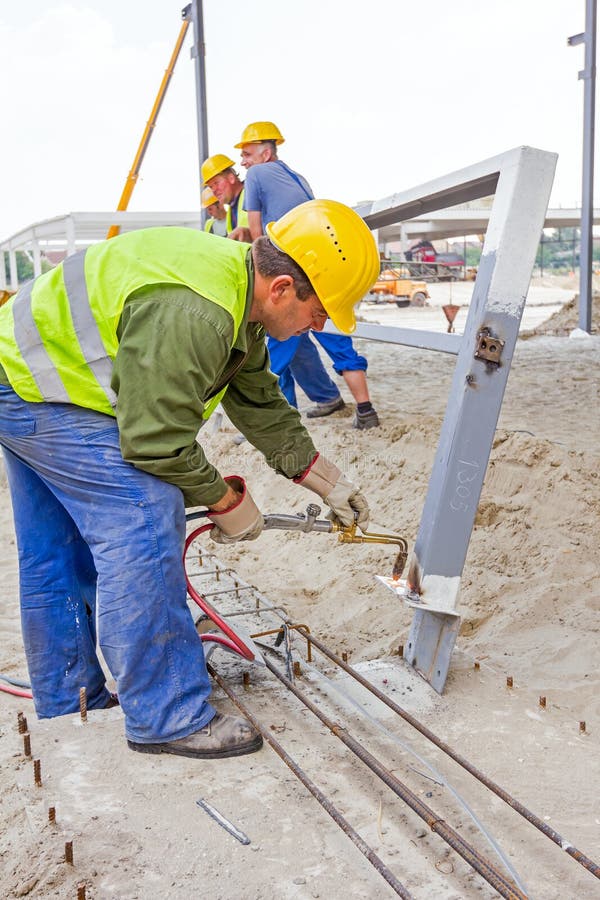 Metalworker is increasing holes diameter using metal torch. Worker is using acetylene torch to cut through metal in metalwork. Shopping center AVIV PARK in Zrenjanin, Vojvodina, Serbia, 04.06.2015. Metalworker is increasing holes diameter using metal torch. Worker is using acetylene torch to cut through metal in metalwork. Shopping center AVIV PARK in Zrenjanin, Vojvodina, Serbia, 04.06.2015.