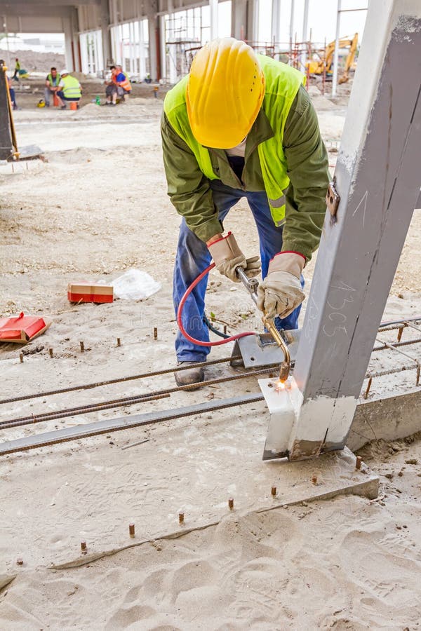 Metalworker is increasing holes diameter using metal torch. Worker is using acetylene torch to cut through metal in metalwork. Shopping center AVIV PARK in Zrenjanin, Vojvodina, Serbia, 04.06.2015. Metalworker is increasing holes diameter using metal torch. Worker is using acetylene torch to cut through metal in metalwork. Shopping center AVIV PARK in Zrenjanin, Vojvodina, Serbia, 04.06.2015.