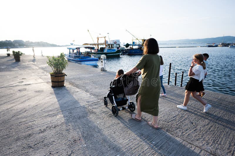 μητέρα και κόρη που περπατούν με καρότσα στην προβλήτα το βράδυ στοκ φωτογραφία