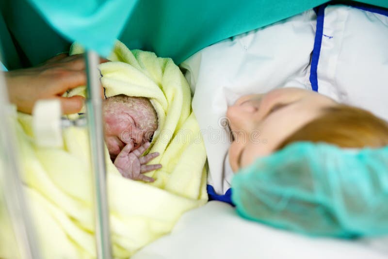 Μητέρα που ψάχνει πρώτα ime το μωρό της που γεννιέται μέσω του τμήματος Caesarean στοκ εικόνες Μητέρα που ψάχνει πρώτα ime το μωρό της που γεννιέται μέσω του τμήματος Caesarean στοκ εικόνες