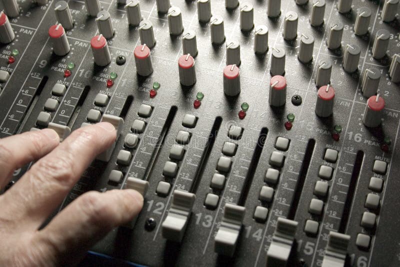 Close-up of sound engineer's hand moving sliders on audio mixing board. Close-up of sound engineer's hand moving sliders on audio mixing board