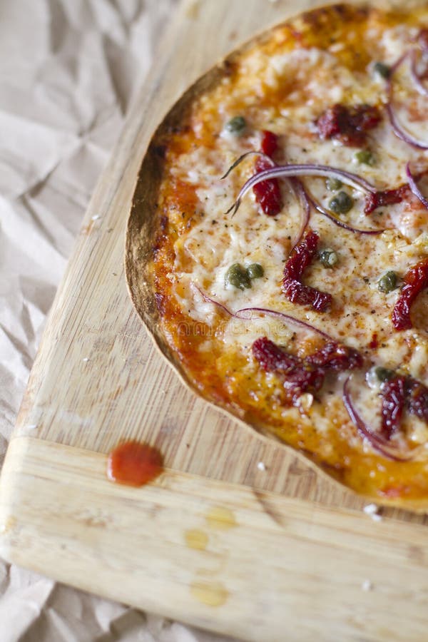 A flatbread tortilla pizza with sundried tomatoes, capers, garlic, red onion, and parmesean cheese. A flatbread tortilla pizza with sundried tomatoes, capers, garlic, red onion, and parmesean cheese.