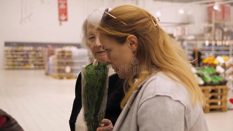 μια γριά γιαγιά με ενήλικη εγγονή σε ένα μεγάλο σούπερ μάρκετ. φιλμ μικρού μήκους