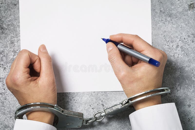 Μια γυναίκα με χειροπέδες υπογράφει ένα κενό φύλλο Έννοια του θέματος της συμφωνίας υπό την επήρεια πιέσεων στους ανθρώπους στοκ φωτογραφίες