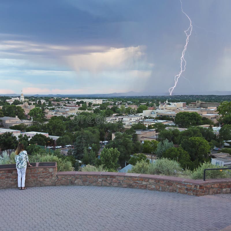A Woman Watches a Lightning Storm from Fort Marcy Park in Santa Fe. A Woman Watches a Lightning Storm from Fort Marcy Park in Santa Fe.