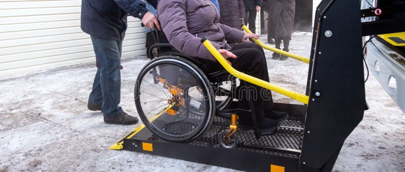 Μια γυναίκα σε μια αναπηρική καρέκλα σε έναν ανελκυστήρα ενός εξειδικευμένου οχήματος για τους ανθρώπους ανάπηρους Ταξί για τα άτ στοκ εικόνες Μια γυναίκα σε μια αναπηρική καρέκλα σε έναν ανελκυστήρα ενός εξειδικευμένου οχήματος για τους ανθρώπους ανάπηρους Ταξί για τα άτ στοκ εικόνες