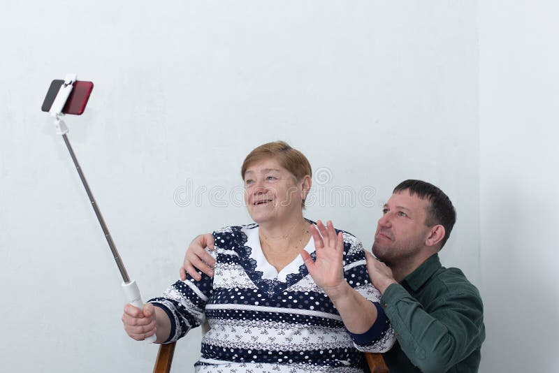 μια ηλικιωμένη γυναίκα με το γιο της να μιλάει στο τηλέφωνο η selfie μένει στο χέρι στοκ εικόνες