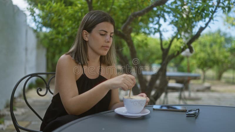 Μια νέα όμορφη ισπανίδα απολαμβάνει καφέ έξω σε μια παράξενη ιταλική καφετέρια στοκ εικόνες