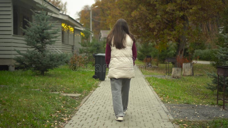Μια νεαρή γυναίκα περπατά όμορφα μέσα από το όμορφο φθινοπωρινό τοπίο βυθισμένο στις αποχρώσεις απόθεμα βίντεο