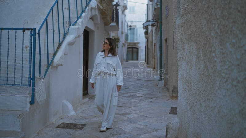 Μια νεαρή ισπανόφωνη περπατά στους όμορφους στενούς δρόμους του polignano a mare στην puglia italy θαυμάζοντας την γαλήνη στοκ εικόνα με δικαίωμα ελεύθερης χρήσης