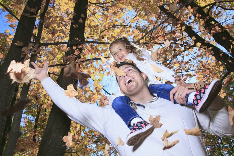 Μια οικογένεια που απολαμβάνει τα χρυσά φύλλα στο πάρκο φθινοπώρου
