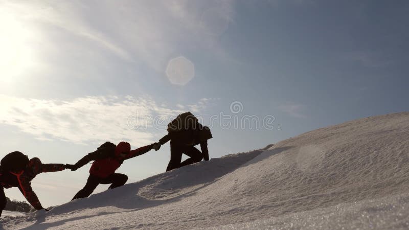 Μια ομάδα των ταξιδιωτών πηγαίνει στο στόχο του, που υπερνικά τις δυσκολίες οι τουρίστες κρατούν τα χέρια αναρριμένος στο χιονώδε