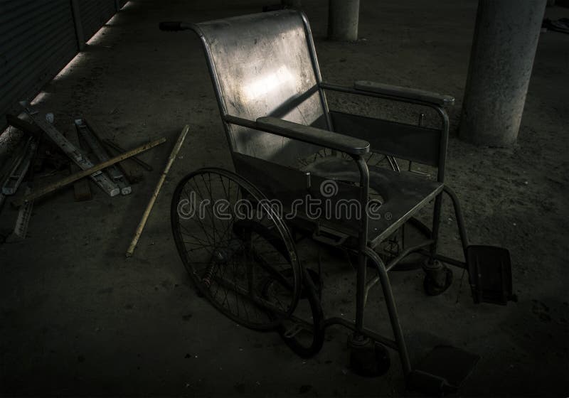 Μια παλαιά αναπηρική καρέκλα στο παλαιό δωμάτιο η παλαιά αναπηρική καρέκλα ήταν αυτό είναι μόνη και τρομακτική έννοια στοκ εικόνες Μια παλαιά αναπηρική καρέκλα στο παλαιό δωμάτιο η παλαιά αναπηρική καρέκλα ήταν αυτό είναι μόνη και τρομακτική έννοια στοκ εικόνες