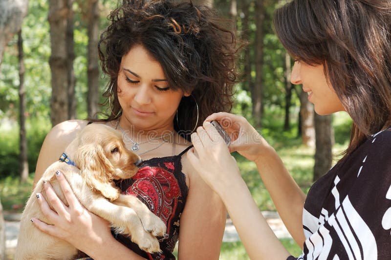 Teenagers playing with a little dog in the park. Teenagers playing with a little dog in the park