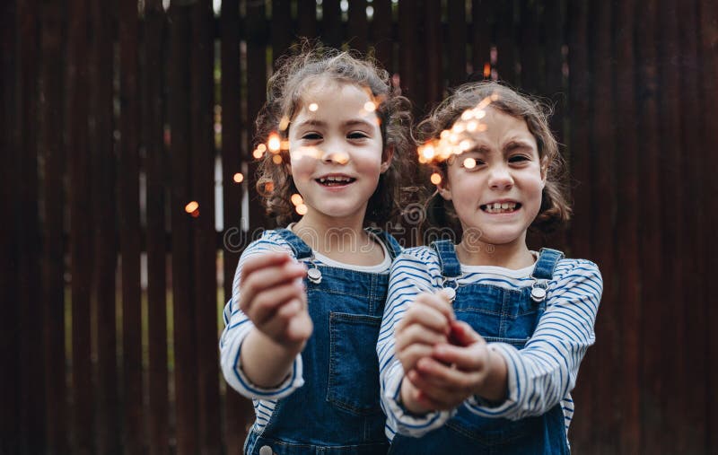 Μικρά κορίτσια που κρατούν τα sparklers υπαίθρια στοκ φωτογραφίες με δικαίωμα ελεύθερης χρήσης Μικρά κορίτσια που κρατούν τα sparklers υπαίθρια στοκ φωτογραφίες με δικαίωμα ελεύθερης χρήσης