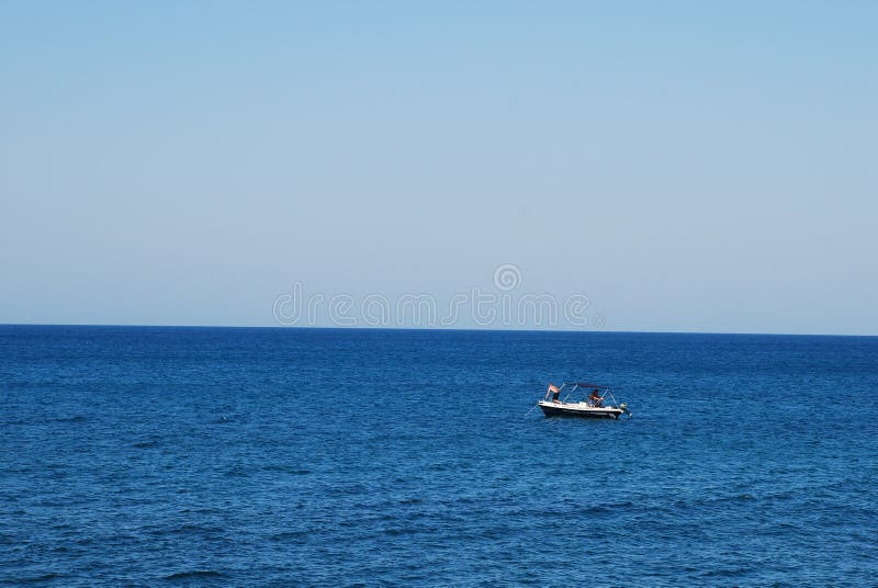 Μικρή βάρκα μηχανών στην μπλε θάλασσα στοκ εικόνα Μικρή βάρκα μηχανών στην μπλε θάλασσα στοκ εικόνα