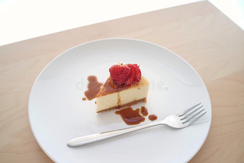 Μικρή φέτα cheesecake σε ένα μεγάλο πιάτο στοκ φωτογραφίες Μικρή φέτα cheesecake σε ένα μεγάλο πιάτο στοκ φωτογραφίες