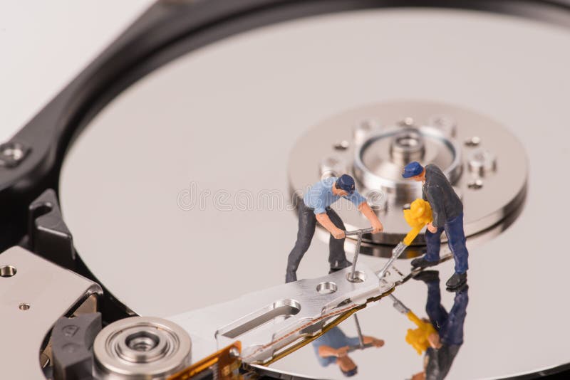 Μικροσκοπικοί άνθρωποι ομάδων Technicial που επισκευάζουν το σκληρό δίσκο στοκ εικόνα με δικαίωμα ελεύθερης χρήσης Μικροσκοπικοί άνθρωποι ομάδων Technicial που επισκευάζουν το σκληρό δίσκο στοκ εικόνα με δικαίωμα ελεύθερης χρήσης