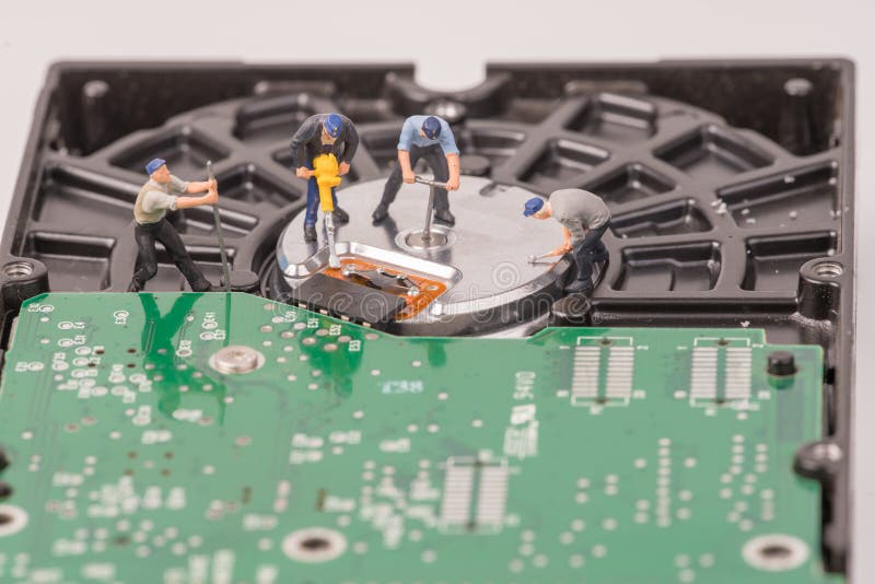 Μικροσκοπικοί άνθρωποι ομάδων Technicial που επισκευάζουν το σκληρό δίσκο στοκ εικόνες Μικροσκοπικοί άνθρωποι ομάδων Technicial που επισκευάζουν το σκληρό δίσκο στοκ εικόνες