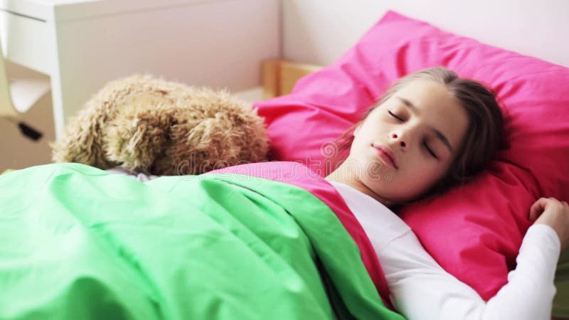 Μικρό κορίτσι με το teddy ύπνο αρκούδων στο σπίτι