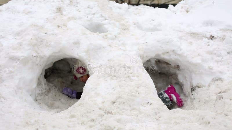 μικρό κορίτσι μπαίνει στην τρύπα με χιονοστιβάδα και απόθεμα βίντεο