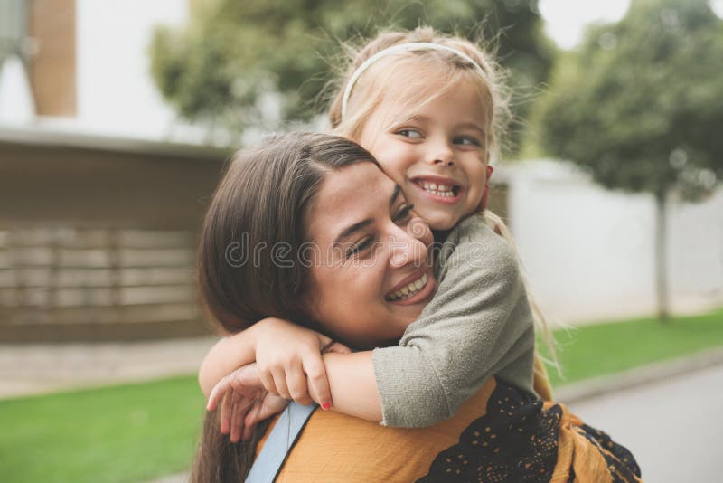 Μικρό κορίτσι στο αγκάλιασμα Moms στοκ φωτογραφία