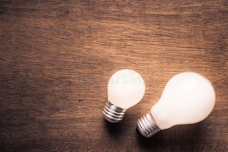 Small and big light bulb, small and medium sized business, coaching, training, or other comparison concept. Small and big light bulb, small and medium sized business, coaching, training, or other comparison concept