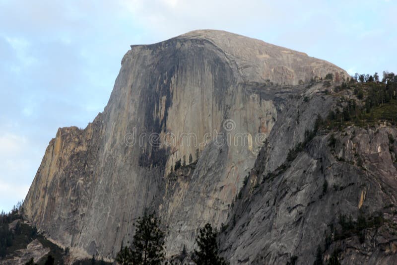 Μισός θόλος, εθνικό πάρκο Yosemite, άποψη Καλιφόρνιας από το χωριό κάρρυ. Μισός θόλος, εθνικό πάρκο Yosemite, Καλιφόρνια, που βλέπει από χώρο στάθμευσης του χωριού το μισό θόλων κάρρυ, θολωτός βράχος γρανίτη με το κάθετα κομμένο μέτωπο αυξανόμενα 1444 μ επάνω από το πάτωμα κοιλάδων