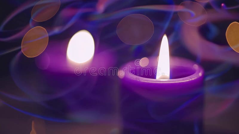 μοβ κεριά με λαμπερή φλόγα σε απαλή εστίαση ατμόσφαιρα με εφέ bokeh. έννοια ηρεμίας και ηρεμίας ελεύθερη απεικόνιση δικαιώματος