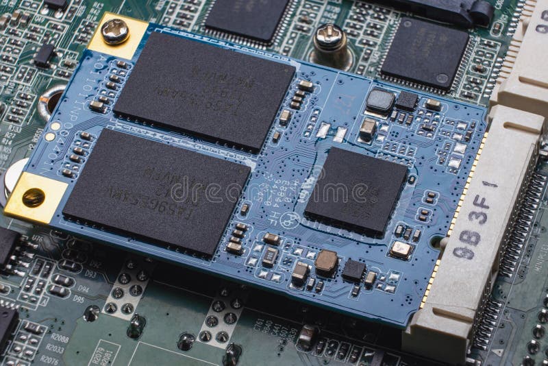 An M.2 format SSD module installed in a slot on the computer's motherboard. Close-up of an electronic circuit board with memory chips and SMD components. An M.2 format SSD module installed in a slot on the computer's motherboard. Close-up of an electronic circuit board with memory chips and SMD components.