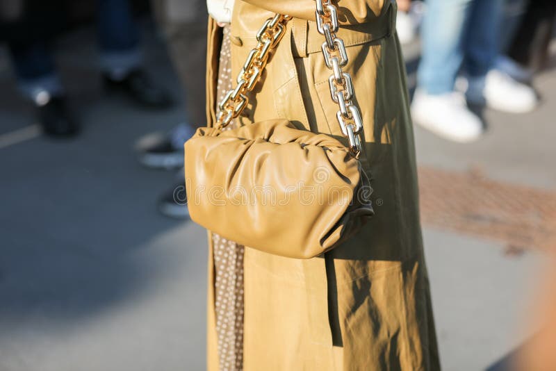 February 19, 2020: model wears an ocher brown overcoat and an oval brown handbag during the Gucci fashion show at the women`s fashion week fall / winter 2020 in Milan. February 19, 2020: model wears an ocher brown overcoat and an oval brown handbag during the Gucci fashion show at the women`s fashion week fall / winter 2020 in Milan