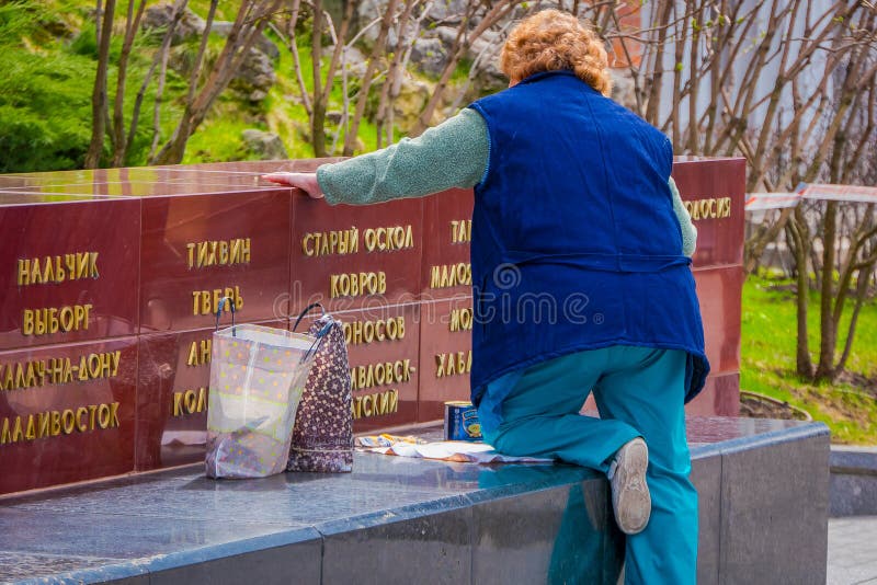 ΜΟΣΧΑ, ΡΩΣΙΑ 29 ΑΠΡΙΛΙΟΥ, 2018: Υπαίθρια άποψη της γυναίκας eldery που φορά τη μπλε ζακέτα στη ζωγραφική πάρκων με το χρυσό χρώμα στοκ φωτογραφία