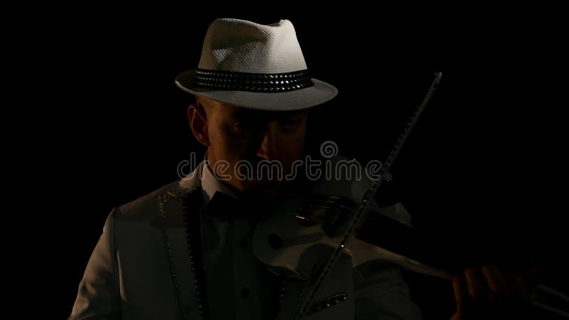 Μουσικός που παίζει ένα βιολί στο μαύρο υπόβαθρο