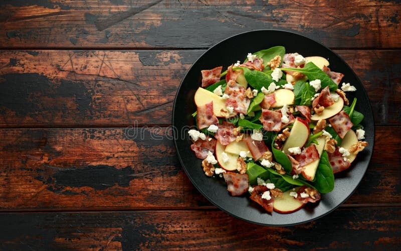 Bacon, Apple Salad with spinach, walnuts and feta cheese. on wooden table. healthy food. Bacon, Apple Salad with spinach, walnuts and feta cheese. on wooden table. healthy food