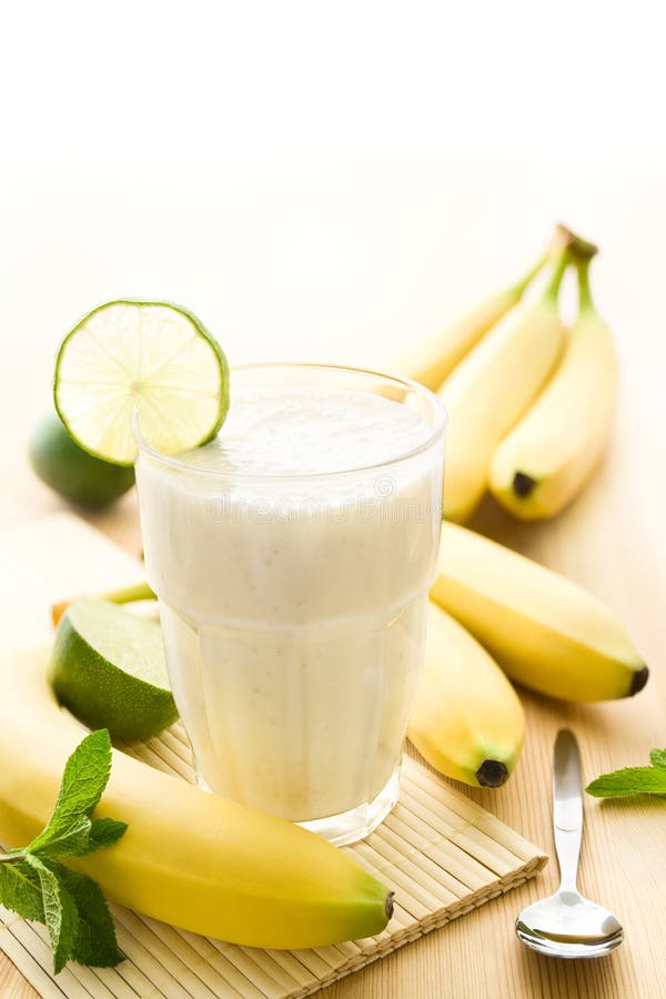 Banana milkshake or smoothie with bananas on wood. Banana milkshake or smoothie with bananas on wood.