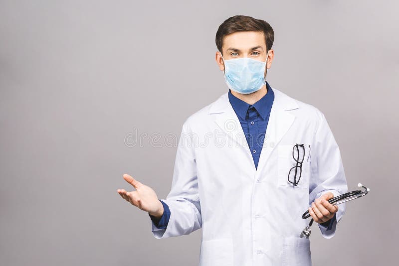 Confused serious male doctor looking at you with stethoscope around his neck, serious face isolated on grey background. Confused serious male doctor looking at you with stethoscope around his neck, serious face isolated on grey background