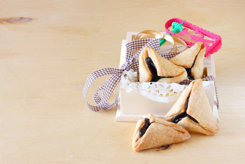 Μπισκότα Hamantaschen ή hamans αυτιά και Noisemaker για τον εορτασμό Purim στο ξύλινο κιβώτιο στοκ εικόνες