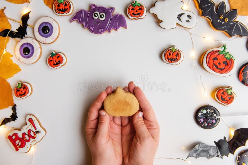 Step by step instructions on how to draw an orange pumpkin shaped gingerbread cookie using icing. Step 1, in the hand lies shape pumpkin of ginger dough. Halloween sweets on white isolated background. Step by step instructions on how to draw an orange pumpkin shaped gingerbread cookie using icing. Step 1, in the hand lies shape pumpkin of ginger dough. Halloween sweets on white isolated background